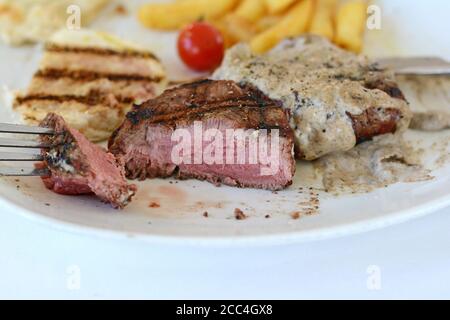 Steak de bœuf rôti moyen avec une sauce aux truffes. Steak grillé avec pommes de terre tard. Banque D'Images