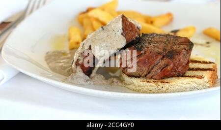 Steak de bœuf rôti moyen avec une sauce aux truffes. Steak grillé avec pommes de terre tard. Banque D'Images