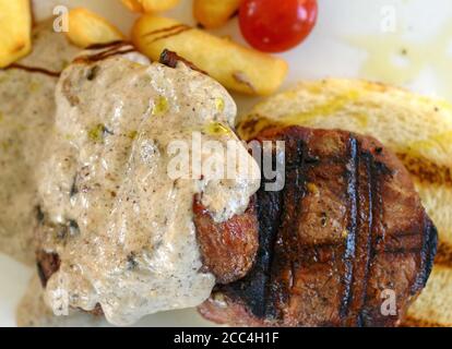 Steak de bœuf rôti moyen avec une sauce aux truffes. Steak grillé avec pommes de terre tard. Banque D'Images