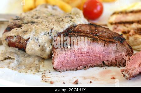 Steak de bœuf rôti moyen avec une sauce aux truffes. Steak grillé avec pommes de terre tard. Banque D'Images