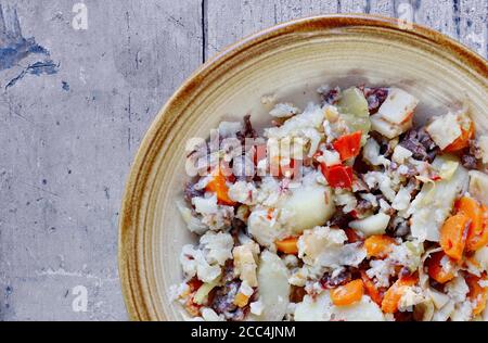 Djuvec riz et légumes dans une assiette sur un bois rustique. Banque D'Images