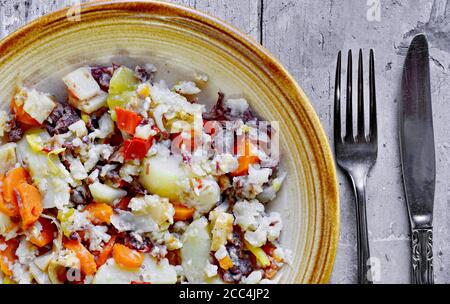 Djuvec riz et légumes dans une assiette sur un bois rustique. Banque D'Images