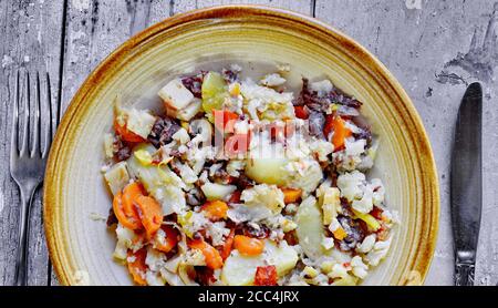 Djuvec riz et légumes dans une assiette sur un bois rustique. Banque D'Images