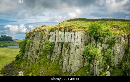 Section du mur d'Hadrien au-dessus du Grand Whin Escarpement de Sill dans le Northumberland en Angleterre avec Crag Lough dans le Arrière-plan Banque D'Images