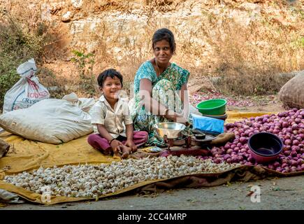 Puttaparthi, Andhra Pradesh, Inde - 13 janvier 2013 : mère et fils vendant de l'ail et des oignons sur le marché de rue de Puttaparthi, Inde Banque D'Images