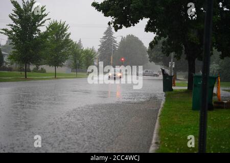 Les citoyens de fond du Lac traversent les rues inondées dans leurs véhicules de l'énorme déversage de pluie durant l'après-midi de juillet 2020. Banque D'Images
