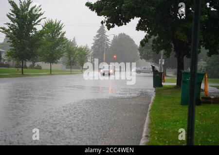Les citoyens de fond du Lac traversent les rues inondées dans leurs véhicules de l'énorme déversage de pluie durant l'après-midi de juillet 2020. Banque D'Images