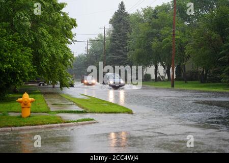 Les citoyens de fond du Lac traversent les rues inondées dans leurs véhicules de l'énorme déversage de pluie durant l'après-midi de juillet 2020. Banque D'Images