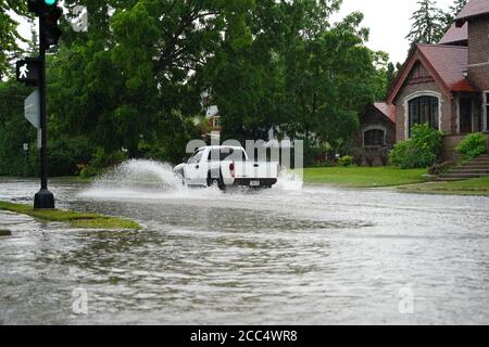 Les citoyens de fond du Lac traversent les rues inondées dans leurs véhicules de l'énorme déversage de pluie durant l'après-midi de juillet 2020. Banque D'Images