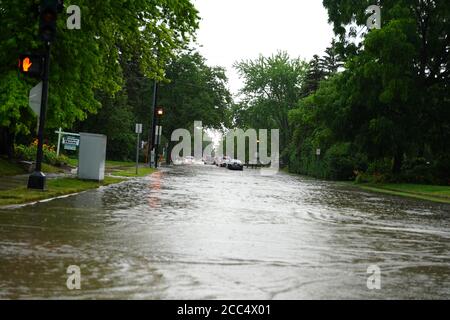 Les citoyens de fond du Lac traversent les rues inondées dans leurs véhicules de l'énorme déversage de pluie durant l'après-midi de juillet 2020. Banque D'Images