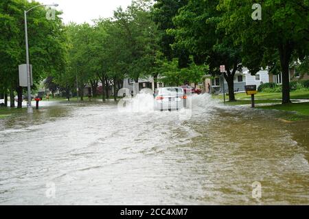 Les citoyens de fond du Lac traversent les rues inondées dans leurs véhicules de l'énorme déversage de pluie durant l'après-midi de juillet 2020. Banque D'Images