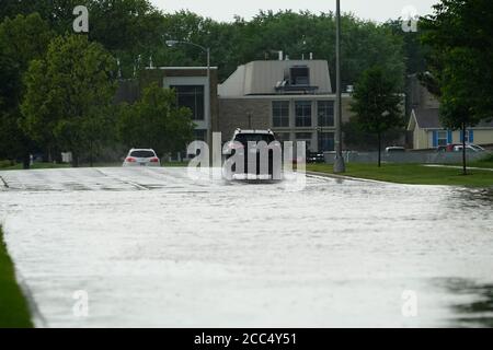 Les citoyens de fond du Lac traversent les rues inondées dans leurs véhicules de l'énorme déversage de pluie durant l'après-midi de juillet 2020. Banque D'Images