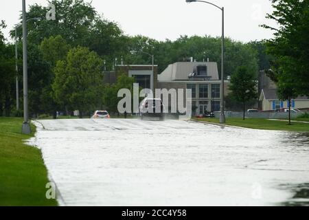 Les citoyens de fond du Lac traversent les rues inondées dans leurs véhicules de l'énorme déversage de pluie durant l'après-midi de juillet 2020. Banque D'Images