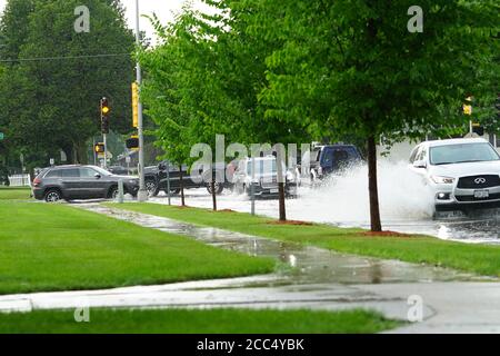Les citoyens de fond du Lac traversent les rues inondées dans leurs véhicules de l'énorme déversage de pluie durant l'après-midi de juillet 2020. Banque D'Images