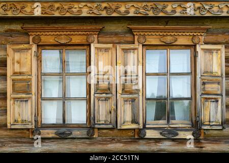 Deux fenêtres en bois avec volets sur le mur du vieux village maison en gros plan Banque D'Images