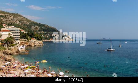 Vue sur la plage de la Plaza Banje avec bains de soleil pour les touristes, le long de la côte adriatique de Dubrovnik, en Croatie Banque D'Images