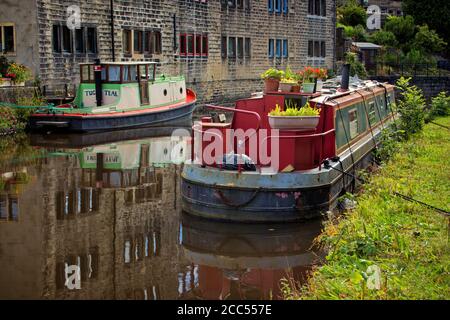 Deux barges amarrées à côté d'un bâtiment sur le canal Richdale, Hebden Bridge, West Yorkshire Banque D'Images