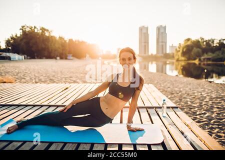 Sportswoman faire du yoga au lever du soleil Banque D'Images