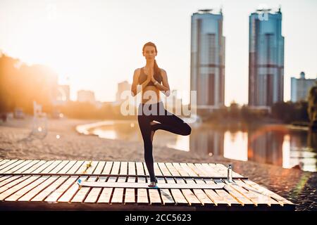Sportswoman faire du yoga au lever du soleil Banque D'Images