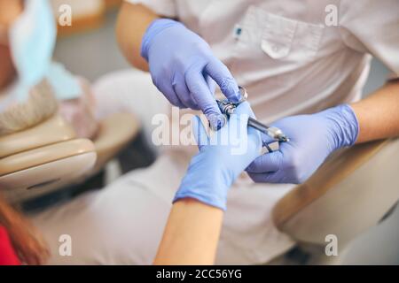 La main du dentiste tient la seringue dentaire Banque D'Images