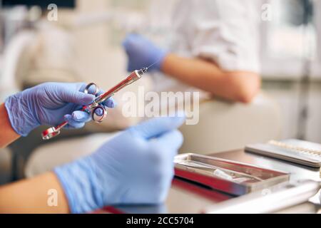 Se concentrer sur les mains de l'homme tenant l'instrument pour la manipulation avec les dents Banque D'Images