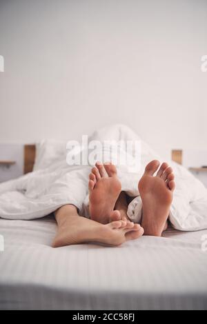 Couple dormant dans le lit à la maison dans une atmosphère confortable Banque D'Images