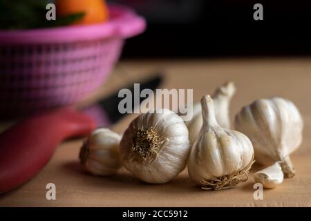 nombre de bulbes à l'ail couteau et panier de légumes sur table à faible profondeur de champ Banque D'Images