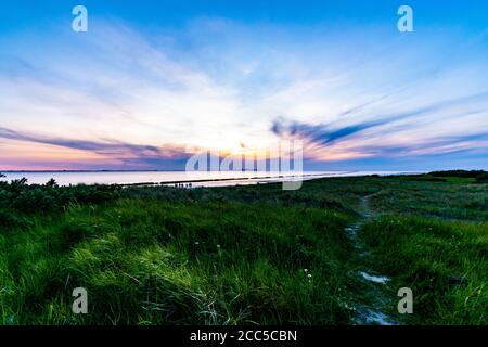 Photo majestueuse d'un magnifique coucher de soleil sur la mer du Nord Près d'Emden pris d'un champ vert frais Banque D'Images