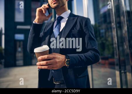 Jeune homme parlant au téléphone à l'extérieur du bureau Banque D'Images