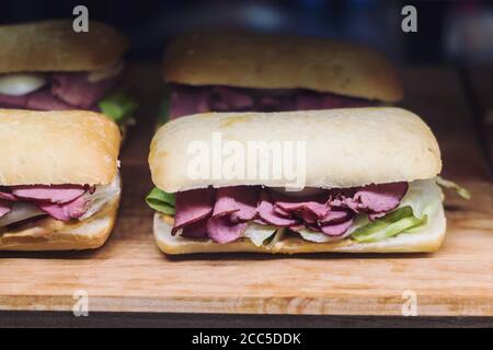 Sandwich au bœuf avec oignon et chou chinois sur coupe de bois carte Banque D'Images