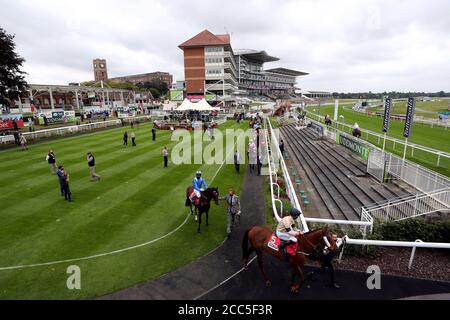 Les coureurs et les cavaliers se rendent à travers le défilé devant le Sky Bet et Symphony Group handicap pendant la première journée du Yorkshire Ebor Festival à l'hippodrome de York. Banque D'Images