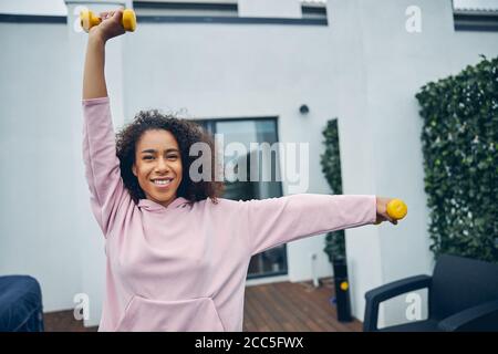 Belle femme avec des cheveux bouclés faisant de l'exercice Banque D'Images