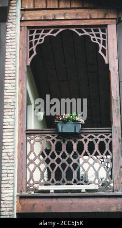 Belles fleurs roses dans un pot sur un balcon en bois en été. Photo verticale Banque D'Images