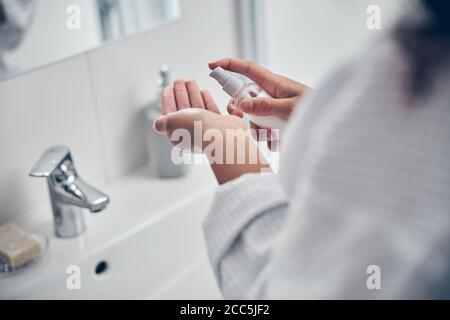 Femme afro-américaine appliquant un produit cosmétique hydratant Banque D'Images