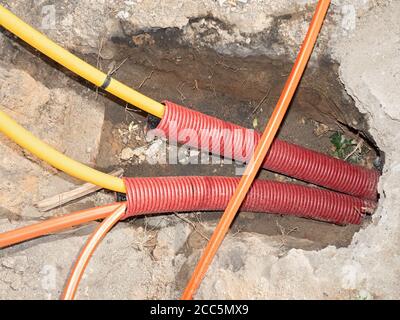 Tranchée de construction avec fils électriques. Travaux routiers pour l'installation de câbles à fibres optiques pour les télécommunications. Banque D'Images