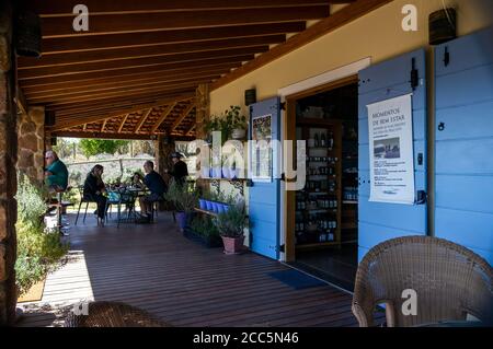 Porche décoré de la boutique de cadeaux de style provençal à l'intérieur de la ferme 'O Lavandario', avec des visiteurs appréciant un café et le beau paysage de Cunha. Banque D'Images