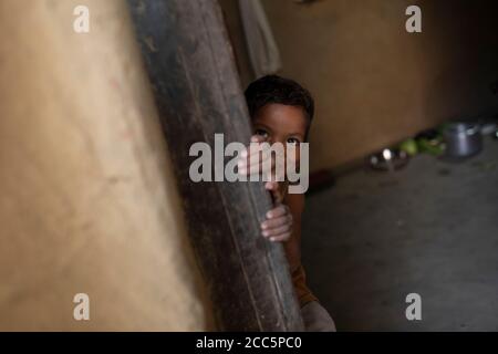 Un garçon de quatre ans se classe hors de la porte de sa maison à Bihar, en Inde, en Asie du Sud. Banque D'Images