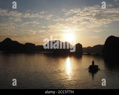 Ombres d'une maison de pagayage de pêcheur au coucher du soleil à LAN Ha Ba, Vietnam Banque D'Images