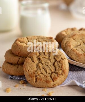 Gros plan des biscuits au beurre d'arachide dans une pile de verre de lait en arrière-plan Banque D'Images