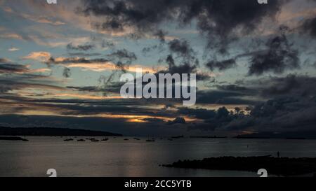 Coucher de soleil doré ciel nuageux vue sur l'océan à English Bay, Vancouver, C.-B., Canada Banque D'Images