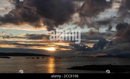 Coucher de soleil doré ciel nuageux vue sur l'océan à English Bay, Vancouver, C.-B., Canada Banque D'Images