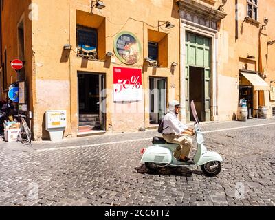 Un homme dans un Vespa scooter à Rione Pigna - Rome, Italie Banque D'Images