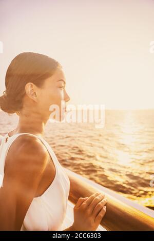 Voyage de luxe croisière élégante femme profitant de la vue sur le coucher du soleil depuis le balcon de la suite terrasse. Europe destination vacances asiatique beauté détente Banque D'Images