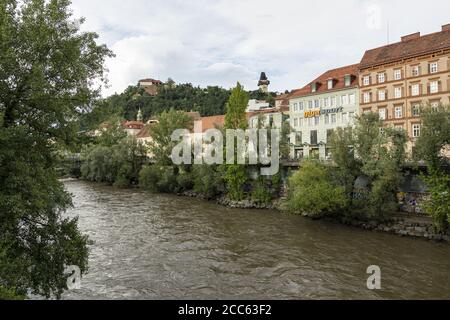 Graz, Autriche. Août 2020. Vue sur la rivière Mura avec le château et la tour de l'horloge en arrière-plan. Banque D'Images