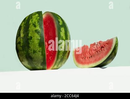 Grande pastèque fraîche et tranche rouge de pastèque sur table sur fond de couleur menthe néo. Concept créatif de fruit d'été minimal. Vue en angle bas Banque D'Images