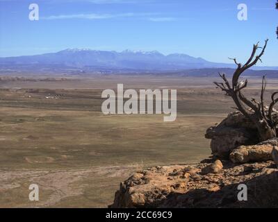 Vue sur les plaines arides de l'est de l'Utah avec les montagnes brumeuses et enneigées de la Sal en arrière-plan lors d'une journée ensoleillée Banque D'Images