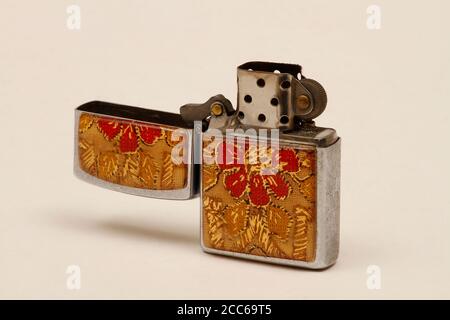 Ouvrir l'ancien briquet dans un capuchon rouge et beige. Un briquet portant une marque ou un logo peut être imprimé sur le couvercle. Banque D'Images