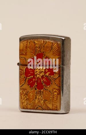 Ouvrir l'ancien briquet dans un capuchon rouge et beige. Un briquet portant une marque ou un logo peut être imprimé sur le couvercle. Banque D'Images