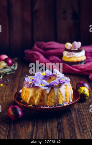 Gâteau traditionnel de Pâques décoré de fleurs de primrose et d'œufs peints en nid naturel Banque D'Images