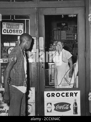 Mme Anna Kelter, 67 ans, regarde avec horreur les dommages causés par les émeutiers à son magasin après la nuit des émeutes en raison de la fusillade fatale de Teen James Powell par le policier Lt. Thomas Gilligan, 551 Nostrand Avenue, Brooklyn, New York, États-Unis, Stanley Wolfson, World Telegram & Sun, 21 juillet 1964 Banque D'Images